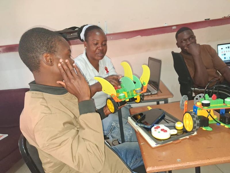 A Mukutronics team member showing students a robot kit
